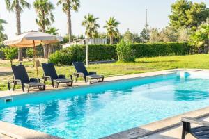 a swimming pool with chairs and an umbrella at Villa Sofia in Sogliano Cavour