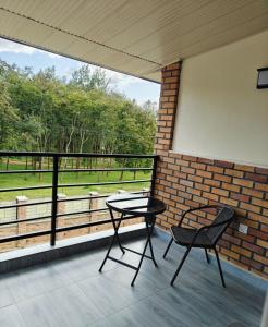 a table and chairs on a balcony with a view of a field at Mansarda parkview Hotel in Nyagatare +12 photos