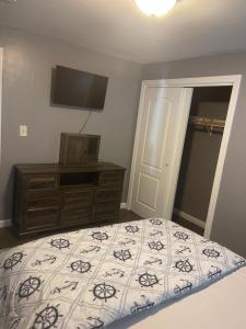 a bedroom with a bed and a dresser and a television at Queeneby in Brockton