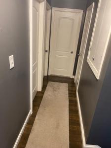 a hallway with a white door and a carpet at Queeneby in Brockton