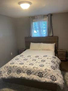 a bedroom with a bed with a comforter and a window at Queeneby in Brockton