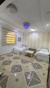 a living room with a tiled floor with couches at اجنحة رحال لشقق الفروشة in Medina