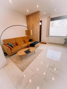 a living room with a couch and a table at AirportHouse in Charleroi +3 photos
