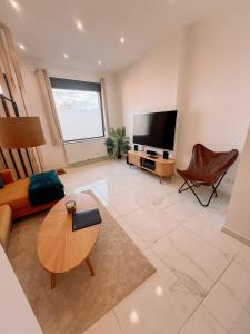 a living room with a tv and a couch and a table at AirportHouse in Charleroi