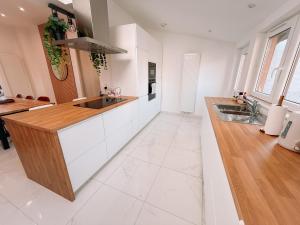 a kitchen with white cabinets and a wooden counter top at AirportHouse in Charleroi