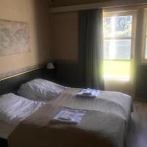 a bed in a room with a window and a bedvisor at Setesdal Motel & Apartments in Bygland +12 photos