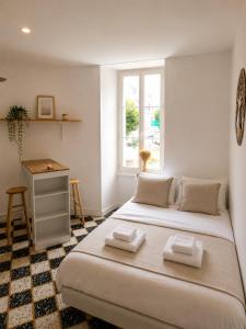 a bedroom with a bed and a desk and a window at Studio Notre Dame in Château-Chinon
