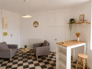 a living room with two chairs and a table at Studio Notre Dame in Château-Chinon