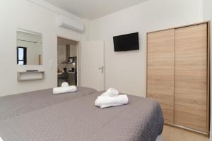 a bedroom with two white towels on a bed at Nimaria Suites in Gialova