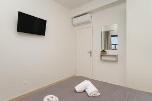 a bedroom with a bed and a tv on a wall at Nimaria Suites in Gialova +97 photos
