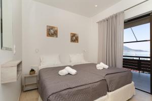 a bedroom with a bed with two towels on it at Nimaria Suites in Gialova