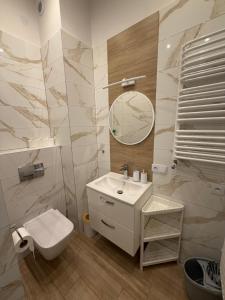 a bathroom with a sink and a toilet and a mirror at Agroturystyka ''Dom Pod Karpiem'' in Zagórze Śląskie