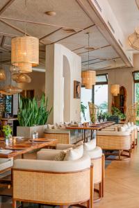 a restaurant with white chairs and tables and windows at Las Lagunas Boutique Hotel in Flores