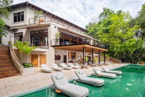 a house with a swimming pool and lounge chairs next to a house at Las Lagunas Boutique Hotel in Flores
