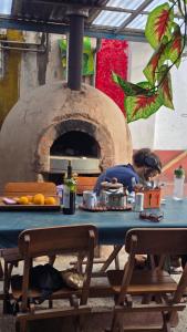 a woman sitting at a table in front of an oven at Moon Garden House in Pisac