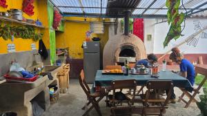 two people sitting at a table in a kitchen with an oven at Moon Garden House in Pisac +28 photos