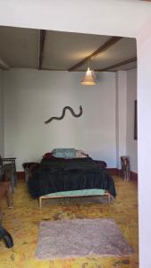 a bedroom with a bed with a black comforter at Moon Garden House in Pisac