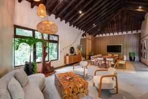 a living room with a table and chairs and a television at Las Lagunas Boutique Hotel in Flores