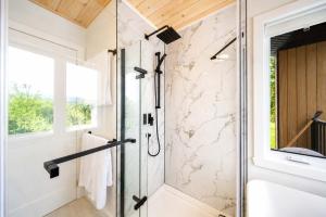 a glass shower in a bathroom with a window at Spa & Foosball - Le WKD in Saint-Philémon +26 photos