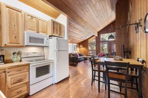 a kitchen with a white refrigerator and a table at Grizzly Den in Whitefish