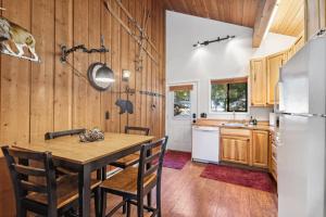 a kitchen with wooden walls and a wooden table and chairs at Grizzly Den in Whitefish