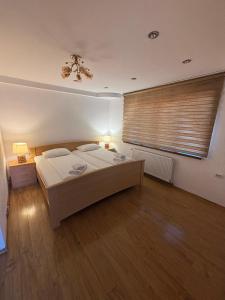 a bedroom with a large bed and a window at Pensiunea Sălaș in Sălaşu de Sus