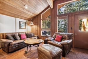a living room with leather furniture and a wooden ceiling at Grizzly Den in Whitefish +20 photos