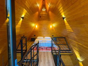 a attic room with a bed in a wooden building at Rivendell Vardzia in T'mogvi