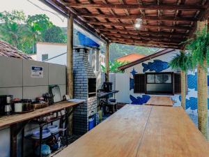 a kitchen with a large wooden table in a room at Ilha Grande Inn in Abraão