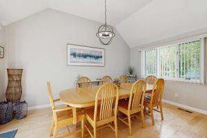 a dining room with a wooden table and chairs at New Seabury Escape in Mashpee