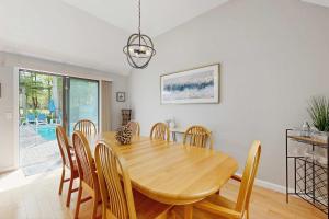 a dining room with a wooden table and chairs at New Seabury Escape in Mashpee