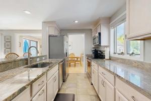 a large kitchen with white cabinets and a sink at New Seabury Escape in Mashpee