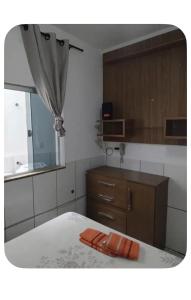 a room with a kitchen with a bed and a window at Casa no centro - perto de tudo in Itaguaí
