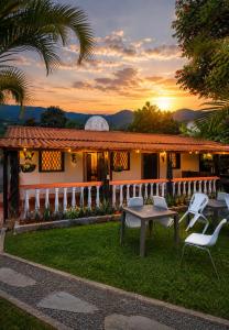 a house with a table and chairs in the yard at Complejo Campestre Salome Cabañas & Hotel in Calima