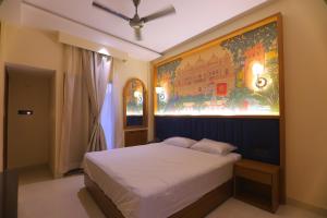a bedroom with a bed with a large painting on the wall at Chunmun Elite Retreat in Bulandshahr