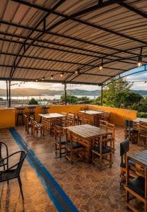 a restaurant with wooden tables and chairs and a roof at Complejo Campestre Salome Cabañas & Hotel in Calima