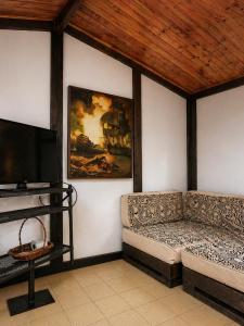 a living room with a couch and a flat screen tv at Complejo Campestre Salome Cabañas & Hotel in Calima