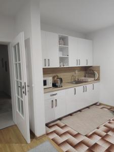 a kitchen with white cabinets and a sink at Villa Ramea in Kovačevo Polje