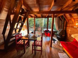 a room with a table and chairs in a cabin at Cabana Aracuã in Três Coroas