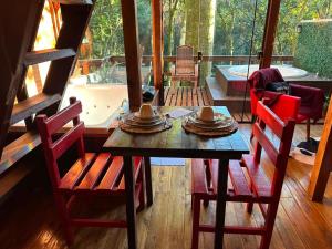 a dining room with a table and chairs and a tub at Cabana Aracuã in Três Coroas +30 photos