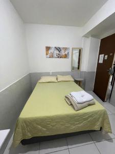 a bedroom with a large bed with a green blanket at JARDIM TROPICAL - QUARTO 03 ar-condicionado in Bayeux +3 photos