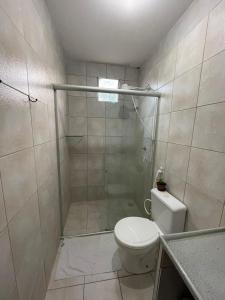 a bathroom with a toilet and a shower at JARDIM TROPICAL - QUARTO 03 ar-condicionado in Bayeux