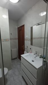 a bathroom with a sink and a toilet and a mirror at Casa Ludi Valdeon in Prada +24 photos