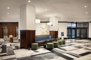 a lobby with a bench and tables and chairs at Hilton Boston Back Bay in Boston