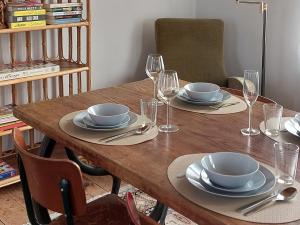 a wooden table with plates and wine glasses on it at De oude statie in Tessenderlo