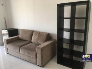 a brown couch in a living room with a book shelf at Apt 2019 in Paulínia