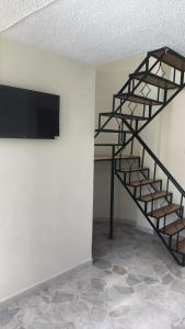 a black spiral staircase in a room with a tv at Villas del Oasis in Ricaurte