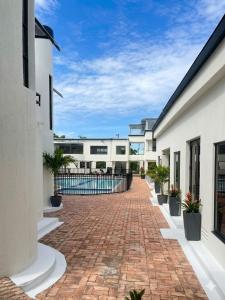 a brick walkway between two buildings with potted plants at Villas del Oasis in Ricaurte
