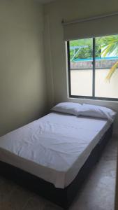 a bed in a room with a window at Villas del Oasis in Ricaurte