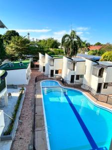 a large swimming pool in front of a building at Villas del Oasis in Ricaurte +12 photos